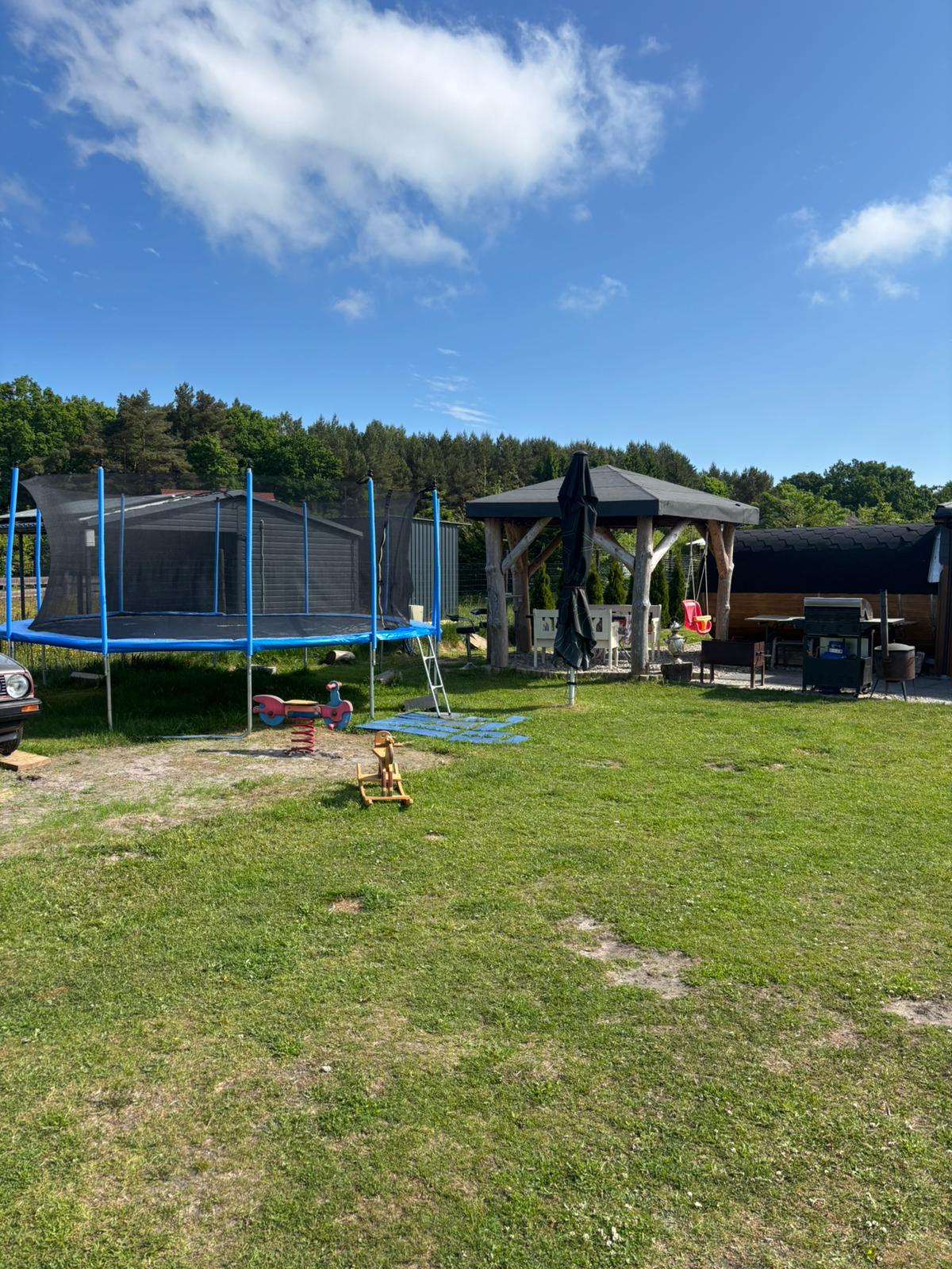Camp-Wiese mit Trampolin, Pavillon und Saunafass