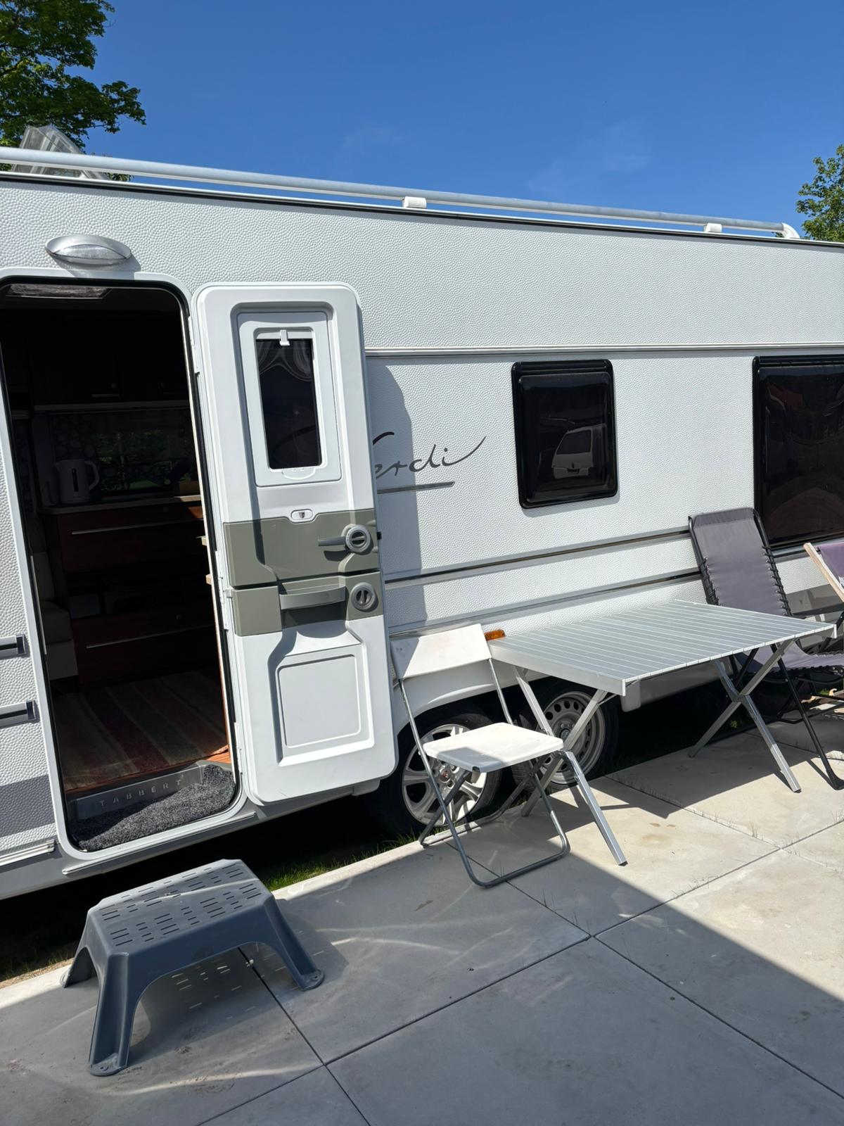 Eingang zum Wohnwagen Anatoli mit Tisch und Hocker